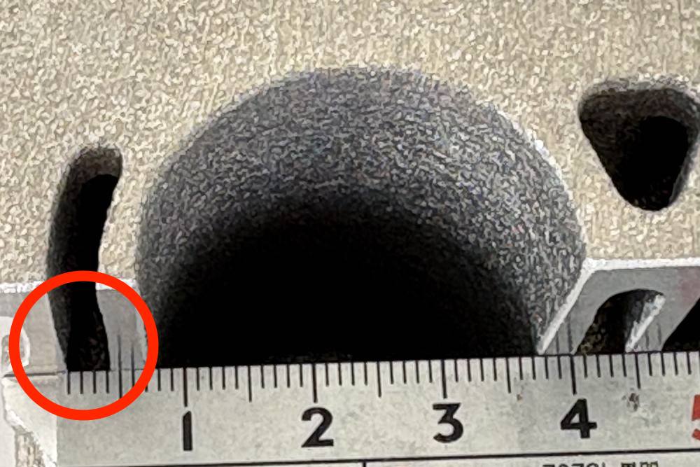 ジャケット部を拡大したところ。円筒状の空洞の脇に細い鋳抜き部があり、下に当てた金属スケールで寸法が示されている。
